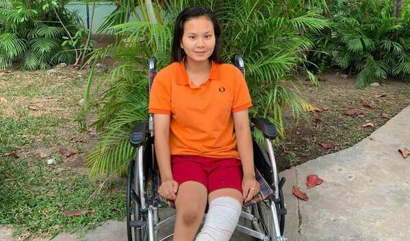 Photo of Sophea on a wheelchair after her clubfoot surgery
